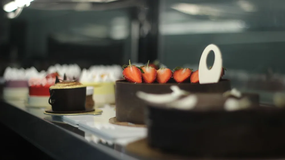 Assorted cakes displayed beautifully in a stylish café, offering a delightful and sweet indulgence.