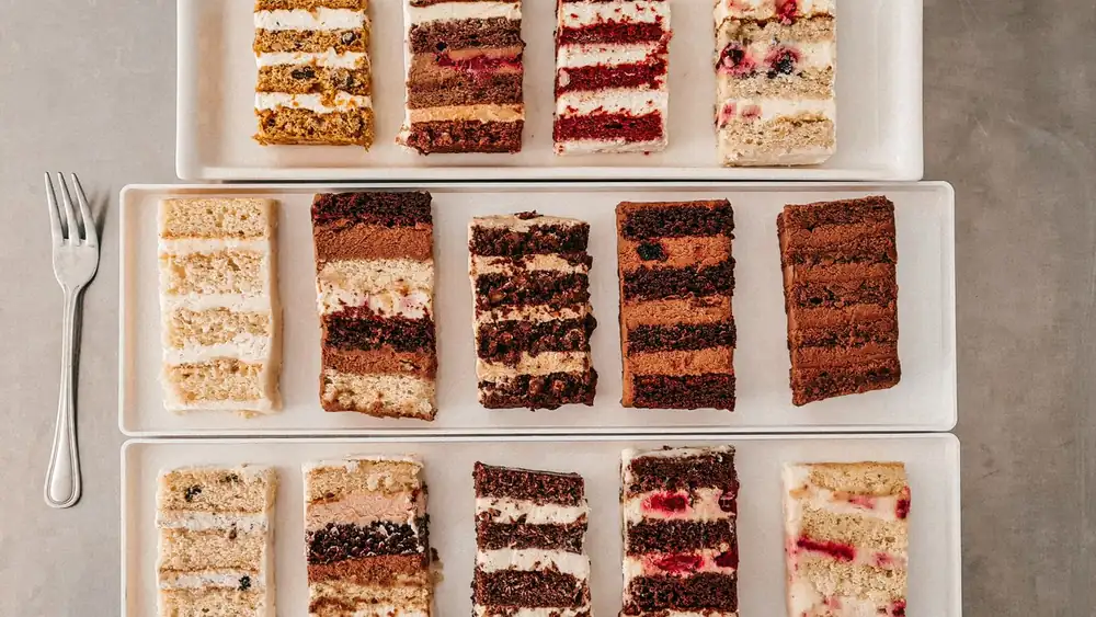 Top view of various cake slices on plates, showcasing textures and flavors.