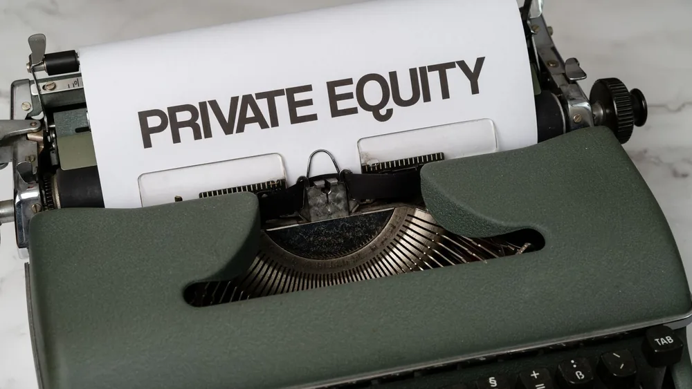 Close-up of vintage typewriter with 'PRIVATE EQUITY' on paper, business concept.