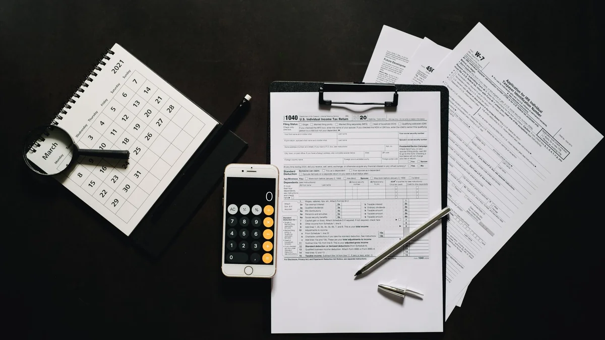 Tax paperwork and a calculator used when working out VAT registration