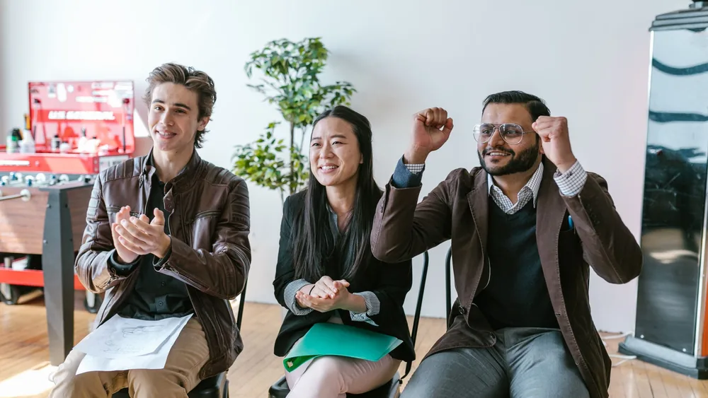 A group of diverse entrepreneurs in a workspace celebrating success and motivation.