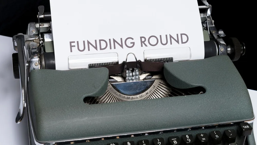 A vintage typewriter displaying the text 'Funding Round,' symbolizing investment and business planning.