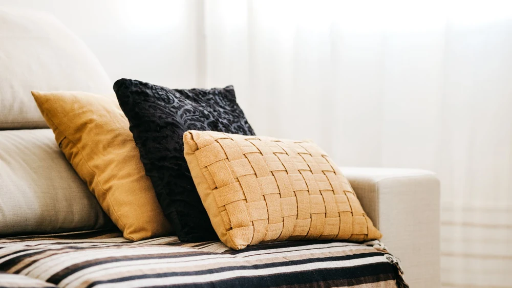 Knitted throws and textured cushions layered on a sofa
