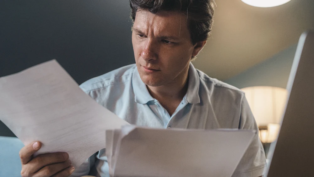 Business owner comparing invoice finance and factoring paperwork